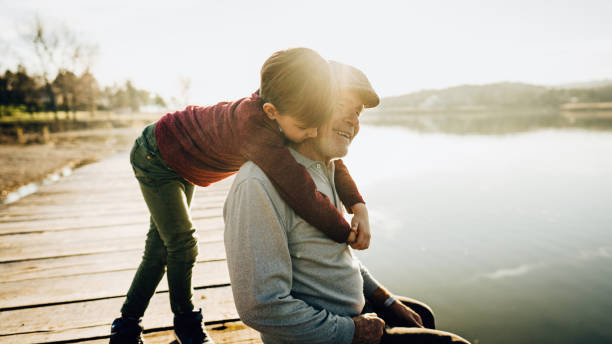 istock Grandfather and grandson on a lake dock 1223789121