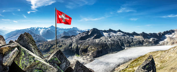 drapeau suisse devant le glacier du rhône - switzerland mountain glacier european alps photos et images de collection