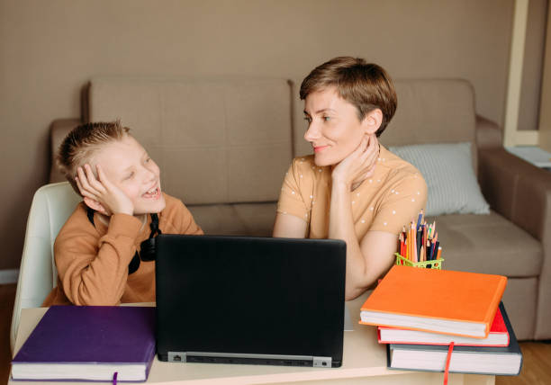 istock Mother teaches child son home online education 1223793140