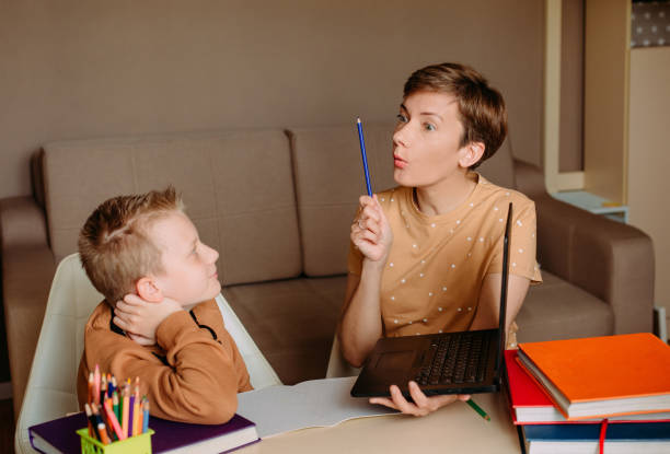 istock Mother teaches child son home online education 1223793146
