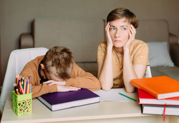 istock Mother teaches child son home online education 1223793155