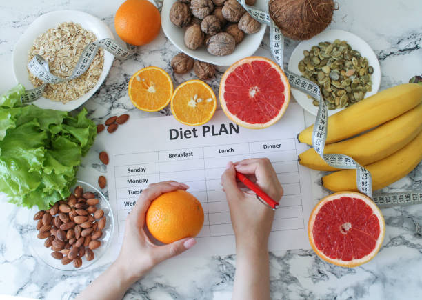 istock Young woman writing a diet plan. Fresh products set top view 1223793353