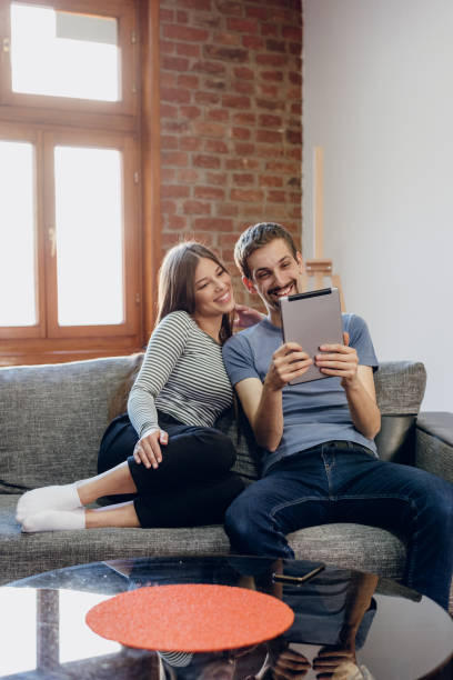 istock Smiling young couple using digital tablet at home 1223798116