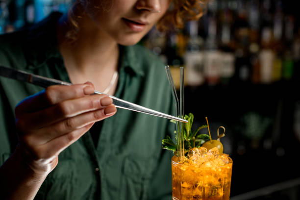 istock Woman using tweezers accurate decorates cocktail by glass sticks 1223807431