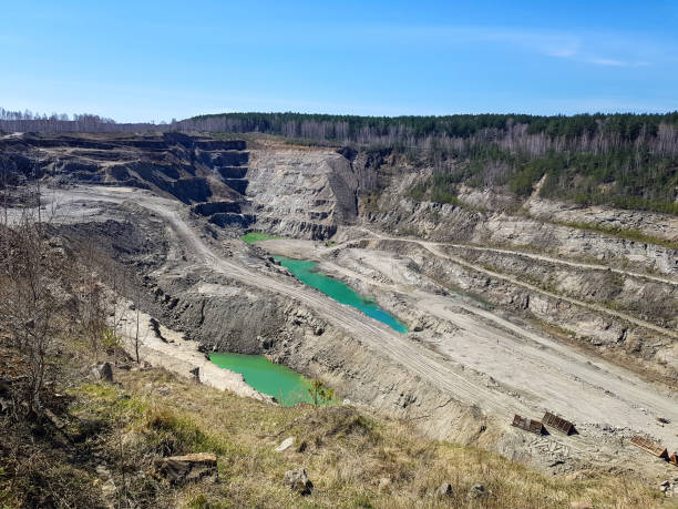 Production of graphite. Deep pit under the open sky. Production of graphite. Industrial background. Deep pit under the open sky. lead mine stock pictures, royalty-free photos & images