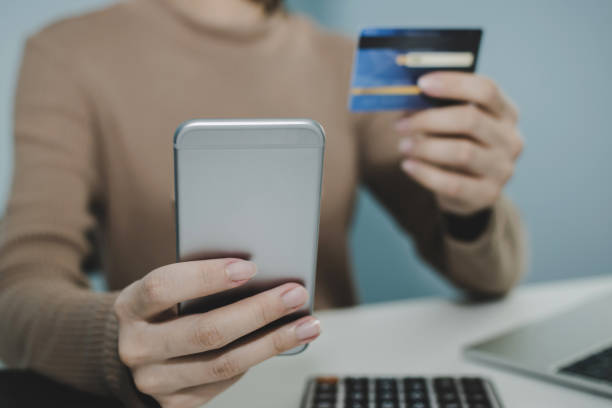 istock young woman entering security code with digital mobile phone and paying with mock up credit card and calculator on desk at home, shopping online, electronic pay, digital marketing, technology concept 1223814532
