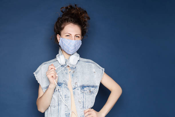 istock Young female wearing mask, checking mobile phone indoors. 1223816953