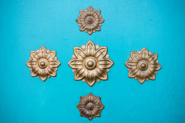 Turquoise wall with ornaments flowers in gold. Texture.