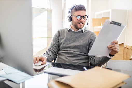 Salesman holding checklist and working at office