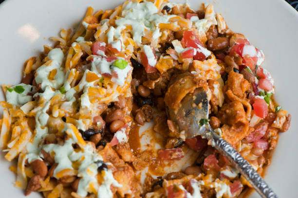 istock Nachos made w/ blue corn tortilla chips with shredded seasoned chicken, cheddar cheese, jalapeños served in homemade corn tortillas & guacamole. Classic Tex-Mex street food served in to-go containers. 1223824507