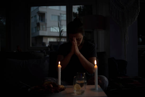 istock Woman praying before eating between the candles 1223824510