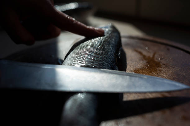 Woman preparing sea bass fish