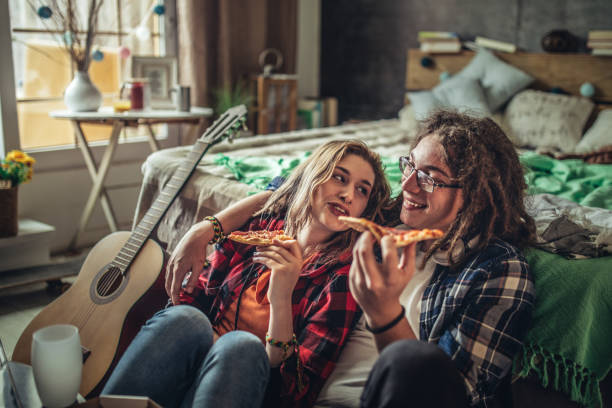 istock Happy couple eating pizza and chatting at home 1223826376