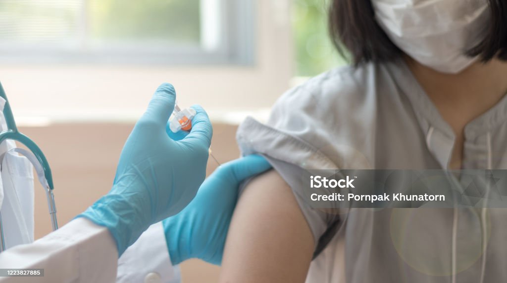 World immunization week and International HPV awareness day concept. Woman having vaccination for influenza or flu shot or HPV prevention with syringe by nurse or medical officer. Vaccination Stock Photo