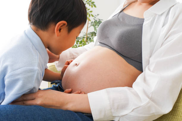 istock Little boy hear the beating of baby 1223829083