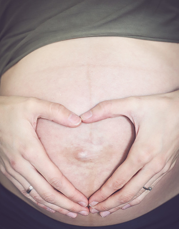 The belly of a pregnant woman, she is waiting for a miracle in New York, New York, United States