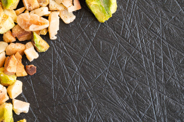 istock Pistachio grain and chopped hazelnuts on a slate board with space for text 1223830862