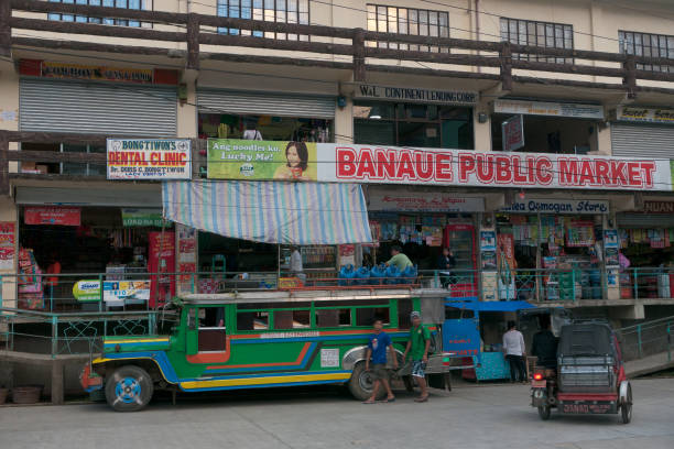 banaue, philippinen - februar 2012: reisen auf den philippinen - ein bus wartet vor einem lokalen geschäft auf passagiere - car people men barn stock-fotos und bilder