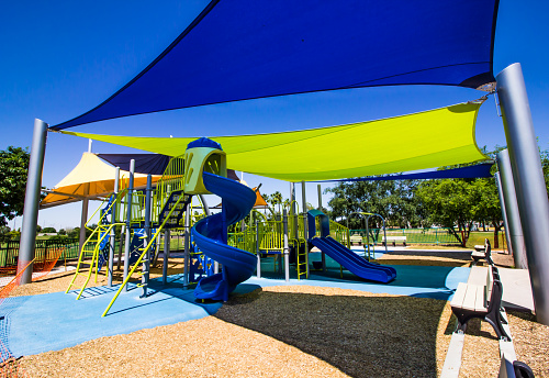 Colorful Shade Canopies Covering Children's Playground Equipment With Slides