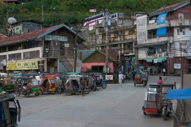 banaue, philippinen - februar 2012: reisen auf den philippinen - ein bahnhof mit trike-motorrädern, die auf passagiere warten - car people men barn stock-fotos und bilder