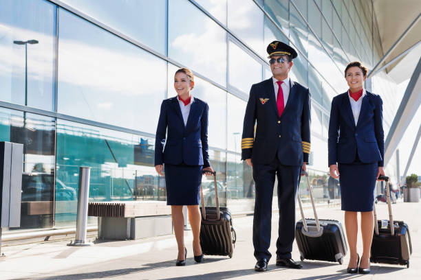 istock Mature pilot with young beautiful flight attendants walking in airport 1223832336