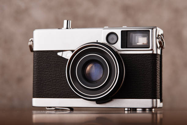 istock Vintage analog rangefinder film camera on wooden table 1223834522