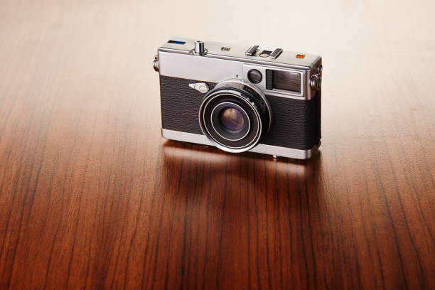 istock Vintage analog rangefinder film camera on wooden table 1223834536