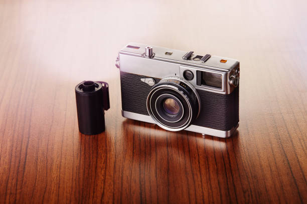 istock Vintage analog rangefinder film camera on wooden table 1223834548