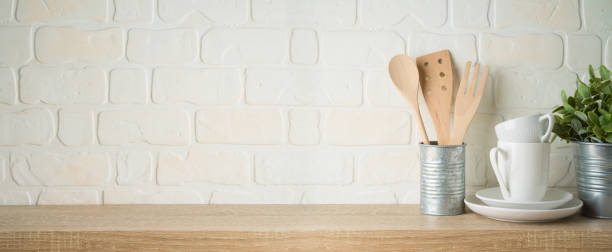 istock Kitchen background with dishware, utensils, cup, plate and plant on wooden shelf 1223835670