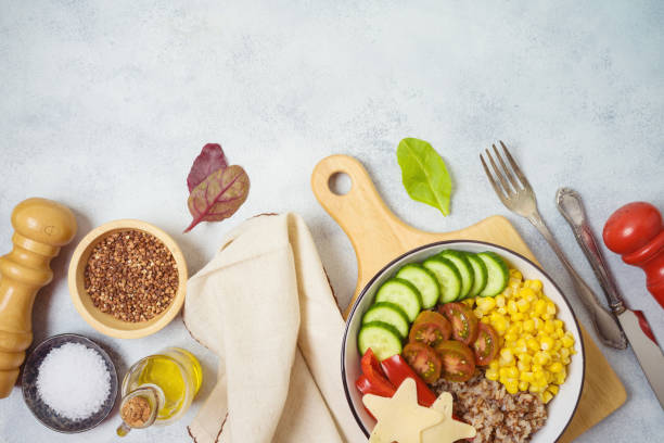 istock Buddha bowl with buckwheat, tomatoes, cucumber, red sweet pepper, corn and cheese on rustic table. Top view from above 1223835682