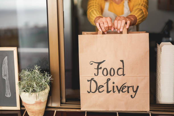 istock Young woman preparing food delivery inside ghost kitchen during quarantine isolation time - Take away meal for online order - Sustainable and healthy food concept - Focus on hands 1223840264
