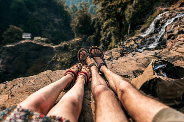 Two durty legs with forest on the background at the edge of the cliff