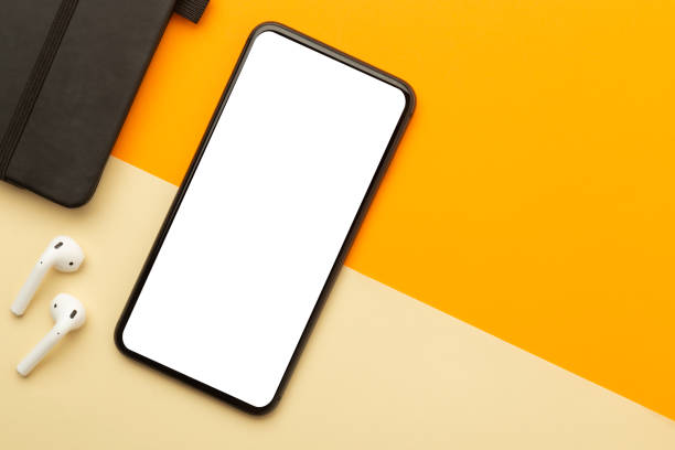 istock Flat lay, top view of orange office table desk with smartphone blank screen mockup with clipping path and wireless earphones, notebook. Modern working space 1223843587