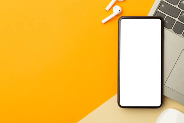 istock Flat lay, top view of orange office table desk with smartphone blank screen mockup with clipping path and wireless earphones, computer. Modern working space 1223843589