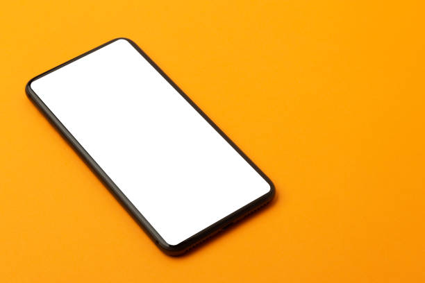 istock Top view of orange office table desk with smartphone blank screen mockup with clipping path. Modern working space 1223843595