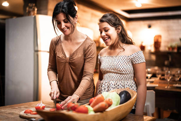 Mother teaching her daughter how to cook at home