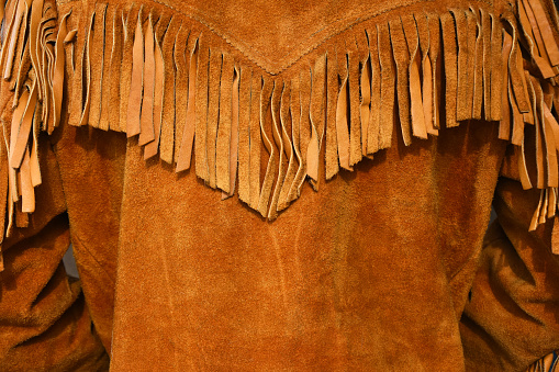 An image of an old vintage style leather coat with long fringes.