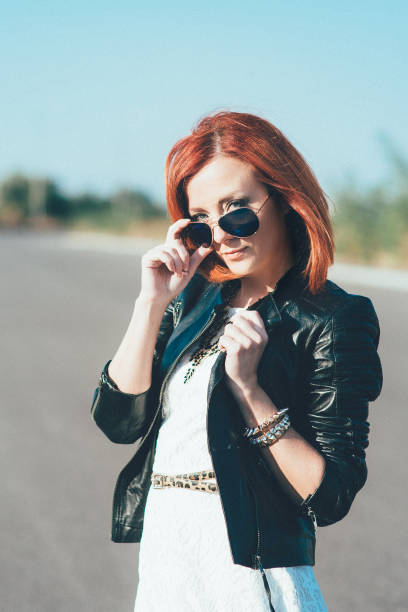 istock red-haired girl in a black jacket and blue glasses 1223846607