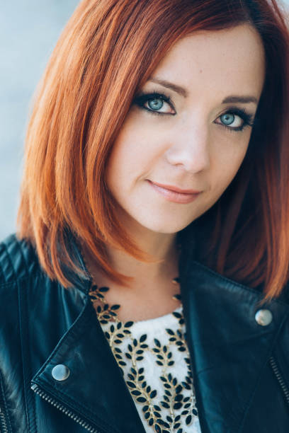 istock red-haired girl in a black jacket and blue glasses 1223847341