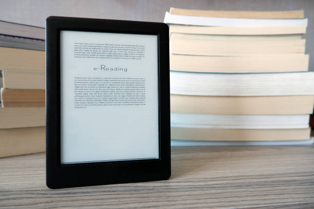 istock n e-book reader is standing in front of of the books 1223847970