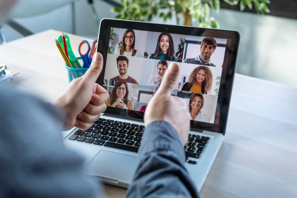 empleado masculino haciendo una aprobación gestuante con los dedos del pulgar mientras habla en videollamada con diversos colegas en la información en línea con la computadora portátil en casa. - telephone conference call old business fotografías e imágenes de stock