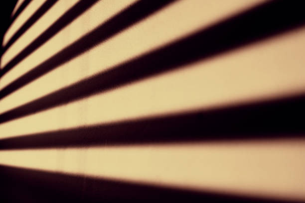 Shadow of venetian blinds cast upon a painted interior wall.  Belfast, Northern Ireland.
