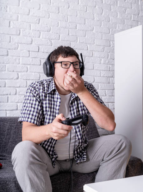 istock young man playing video games at home eating popcorn 1223852844