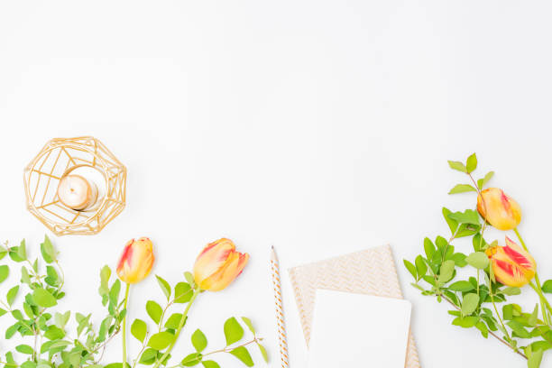 istock Flat lay blogger or freelancer workspace with a notebook and yellow tulips, branches with green leaves on a white background 1223852992