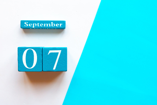 September 7, empty blue and white geometric background. Wooden handmade calendar