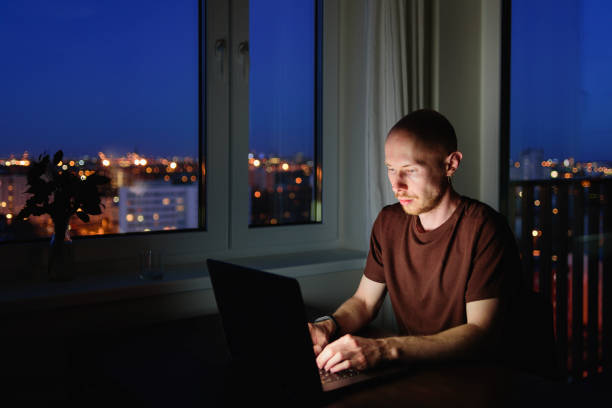 istock Man working on laptop from home at night 1223858610