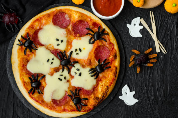 istock Halloween Pizza Monsters with cheese Ghost and olive Spider on a black background. Food idea for Halloween party. 1223860002