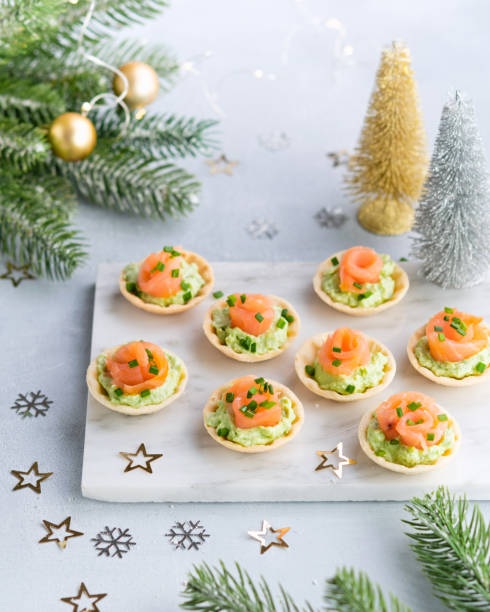 istock Holiday appetizer canapes with salmon avocado cream cheese on a light background with Christmas decorations. Festive table recipe ideas for New Year's and Christmas holidays. 1223864076