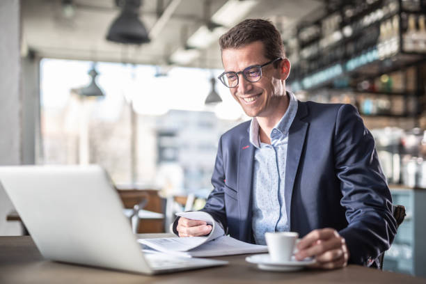 istock Entrepreneur smiles at the computer screen while having a coffee during a business break in a vintage restaurant. 1223870691
