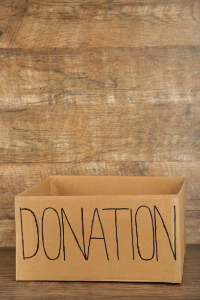 istock Empty cardboard donation box on brown background. Inscription donation 1223870863